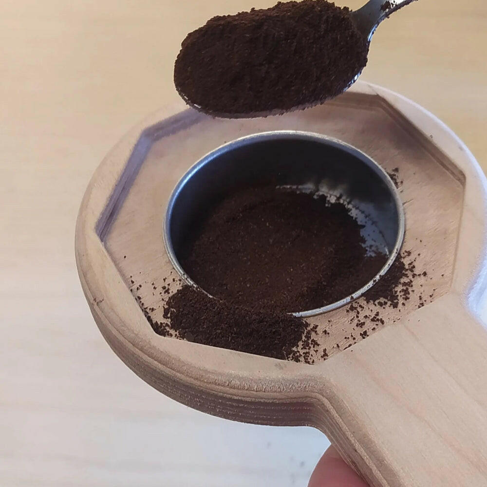 Aprimoka  e porta caffè inserito nel suo foro centrale, il porta caffè sta per essere riempito con caffè fresco ma un pò anche se caduto fuori  rimane nell'aprimoka