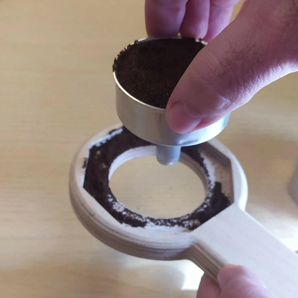 porta caffè appena riempito che viene tolto dall'aprimoka e la polvere di caffè in più rimane nell'aprimoka e con cade sul piano di lavoro e può eseere facilmente recuperata.