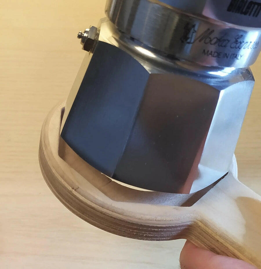 Caffettiera Bialetti Moka Express 3 tazze ripresa nel momento in cui si inserice nell'aprimoka che ne renderà più facile l'apertira (particolare)