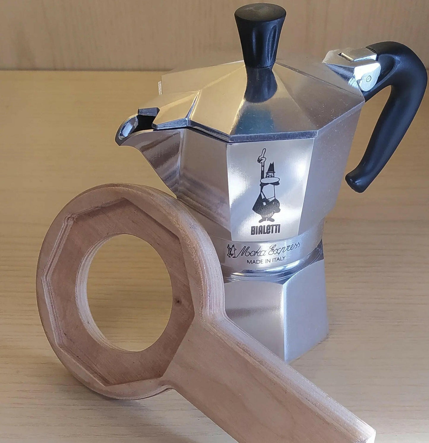 Aprimoka in legno appoggiato ad una caffettiera Bialetti Moka Express  Tazze